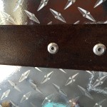 Detail of force rusted metal bar and rivets.